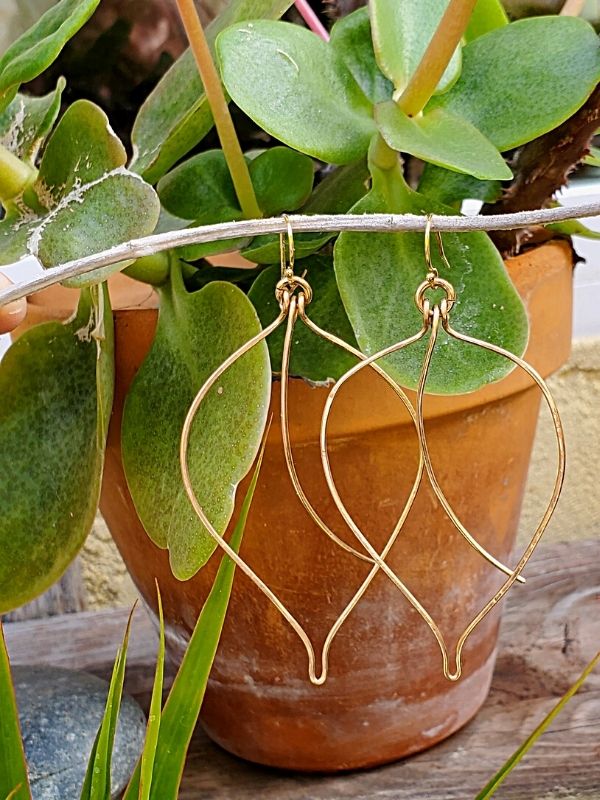 bronze leaf earrings on plant